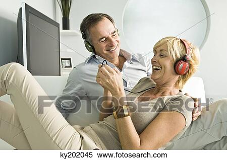 Couple listening to music with headphones and smiling View Large Photo Image Stock Photography - Couple listening to music with headphones and smiling. Fotosearch