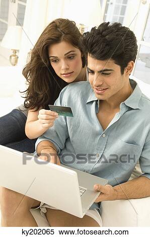 Stock Photography - Couple shopping online with a credit card. Fotosearch