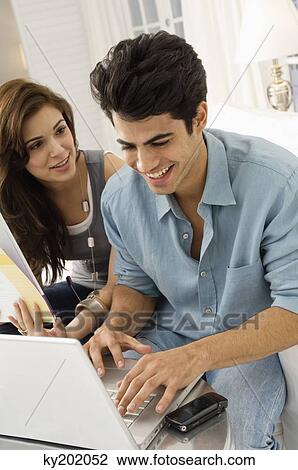 Couple using a laptop and smiling View Large Photo Image Stock Image - Couple using a laptop and smiling. Fotosearch