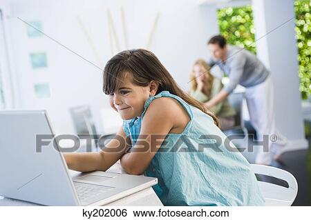 Stock Photograph - Girl using a laptop at home. Fotosearch