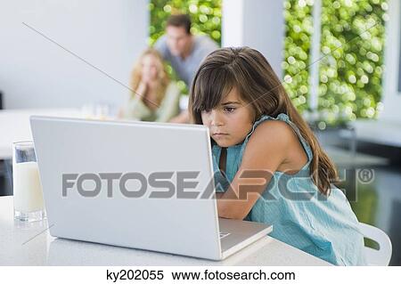Girl using a laptop at home View Large Photo Image Stock Photography - Girl using a laptop at home. Fotosearch