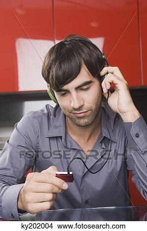 Picture - Man listening to an MP3 player. Fotosearch