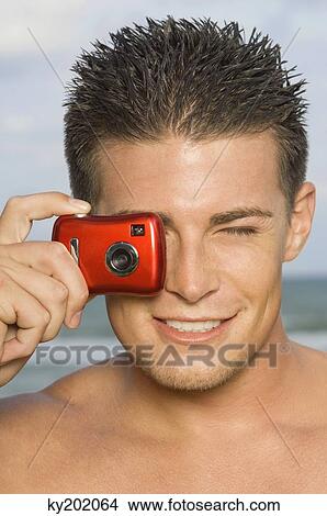 Picture - Man taking a picture with a digital camera. Fotosearch