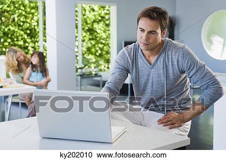 Stock Image - Man working on a laptop. Fotosearch