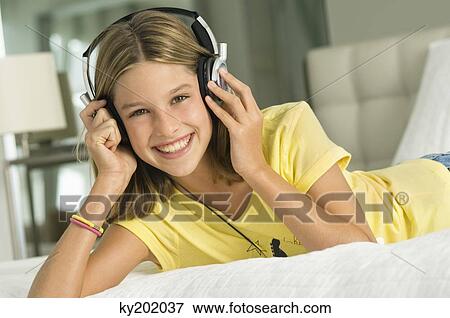 Portrait of a girl listening to music with headphones View Large Photo Image Stock Photo - Portrait of a girl listening to music with headphones. Fotosearch