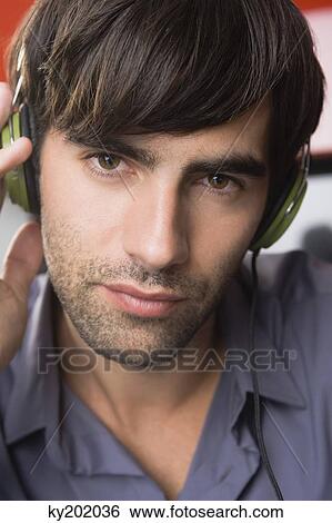 Portrait of a man listening to headphones View Large Photo Image Stock Photograph - Portrait of a man listening to headphones. Fotosearch