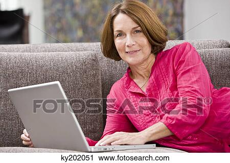 Portrait of a woman working on a laptop View Large Photo Image Stock Image - Portrait of a woman working on a laptop. Fotosearch
