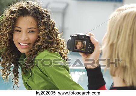 Teenage boy taking a picture of a girl with a digital camera View Large Photo Image Stock Photography - Teenage boy taking a picture of a girl with a digital camera. Fotosearch