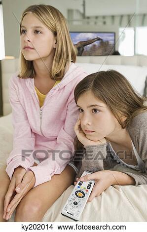 Picture - Two girls watching television. Fotosearch