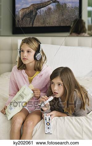 Two girls watching television View Large Photo Image Stock Image - Two girls watching television. Fotosearch