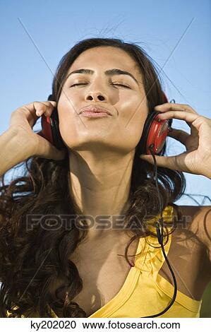 Woman listening to headphones View Large Photo Image Stock Image - Woman listening to headphones. Fotosearch