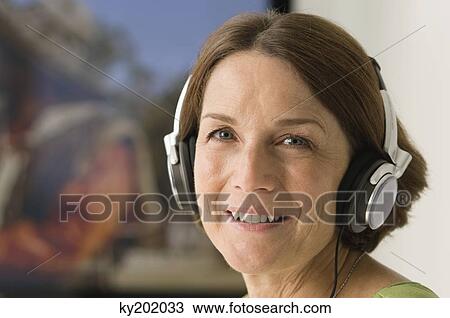 Woman listening to headphones View Large Photo Image Stock Image - Woman listening to headphones. Fotosearch