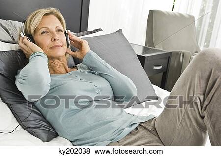 Woman listening to music with headphones View Large Photo Image Stock Photo - Woman listening to music with headphones. Fotosearch