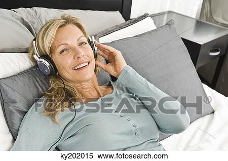 Stock Photography - Woman listening to music with headphones. Fotosearch