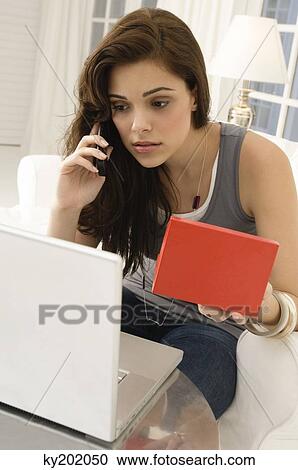Woman shopping online and talking on a mobile phone View Large Photo Image Stock Image - Woman shopping online and talking on a mobile phone. Fotosearch