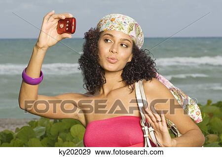 Woman taking a picture of herself with a digital camera View Large Photo Image Stock Photo - Woman taking a picture of herself with a digital camera. Fotosearch