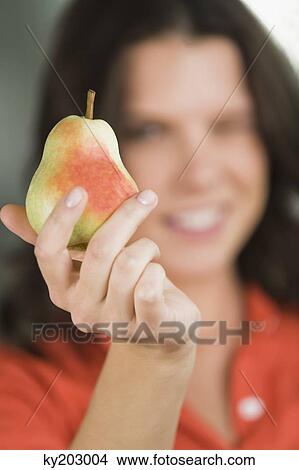 Close-up of a pear in a woman's hand View Large Photo Image Picture - Close-up of a pear in a woman's hand. Fotosearch