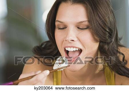 Close-up of a woman eating sushi View Large Photo Image Picture - Close-up of a woman eating sushi. Fotosearch
