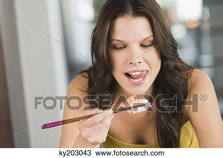 Close-up of a woman eating sushi View Large Photo Image Stock Image - Close-up of a woman eating sushi. Fotosearch