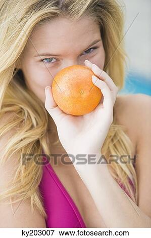 Close-up of a woman holding an orange View Large Photo Image Stock Photo - Close-up of a woman holding an orange. Fotosearch