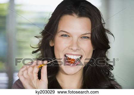 Portrait of a woman eating a berry View Large Photo Image Stock Photo - Portrait of a woman eating a berry. Fotosearch
