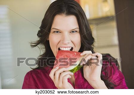 Portrait of a woman eating a slice of watermelon View Large Photo Image Stock Image - Portrait of a woman eating a slice of watermelon. Fotosearch