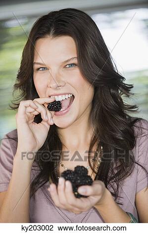 Portrait of a woman eating blackberries View Large Photo Image Stock Image - Portrait of a woman eating blackberries. Fotosearch