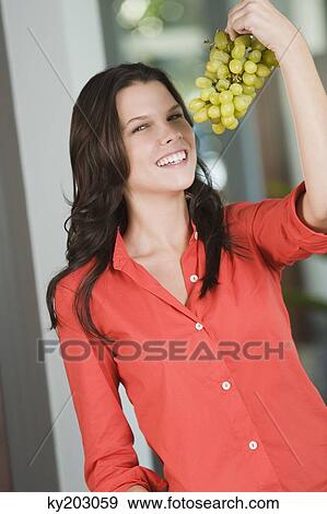 Portrait of a woman holding a bunch of grapes View Large Photo Image Stock Photo - Portrait of a woman holding a bunch of grapes. Fotosearch