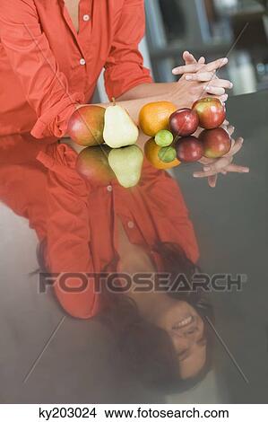 Reflection of a woman and fruits on a kitchen counter View Large Photo Image Picture - Reflection of a woman and fruits on a kitchen counter. Fotosearch