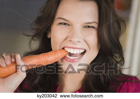 Woman eating a carrot View Large Photo Image Stock Image - Woman eating a carrot. Fotosearch