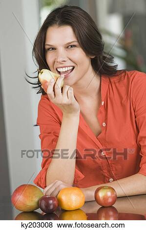 Woman eating a pear and smiling View Large Photo Image Stock Photo - Woman eating a pear and smiling. Fotosearch