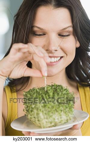 Woman eating bean sprouts and smiling View Large Photo Image Stock Image - Woman eating bean sprouts and smiling. Fotosearch