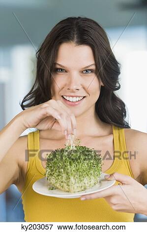 Woman eating bean sprouts and smiling View Large Photo Image Stock Photo - Woman eating bean sprouts and smiling. Fotosearch