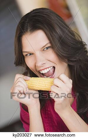 Woman eating corn on the cob View Large Photo Image Stock Photo - Woman eating corn on the cob. Fotosearch