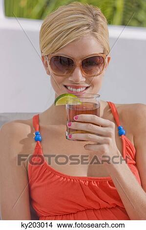 Picture - Woman holding a glass of cola. Fotosearch