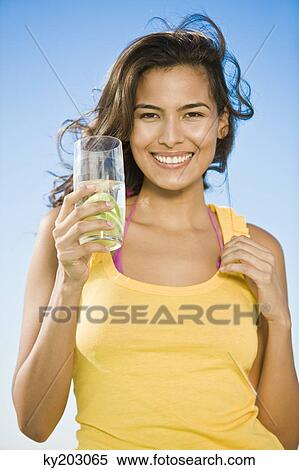 Woman holding a glass of lemonade View Large Photo Image Stock Photography - Woman holding a glass of lemonade. Fotosearch