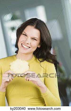 Woman holding a slice of pineapple View Large Photo Image Stock Image - Woman holding a slice of pineapple. Fotosearch