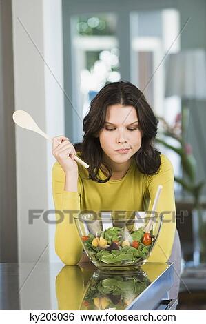 Stock Photograph - Woman looking at a bowl of salad. Fotosearch