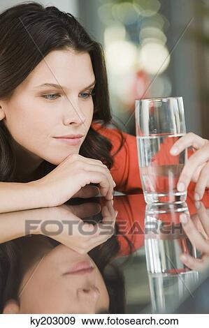 Woman looking at a glass of water View Large Photo Image Stock Photo - Woman looking at a glass of water. Fotosearch