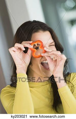 Woman looking through a slice of red bell pepper View Large Photo Image Stock Image - Woman looking through a slice of red bell pepper. Fotosearch