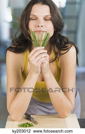Stock Image - Woman smelling chives. Fotosearch