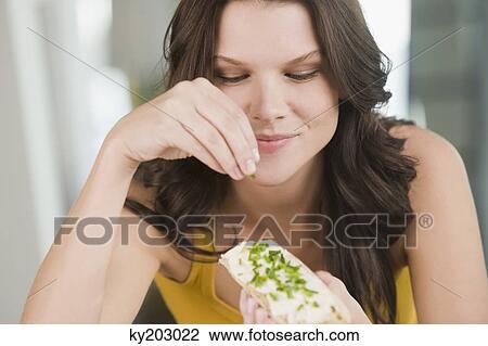 Woman sprinkling chive on a bread and smiling View Large Photo Image Stock Image - Woman sprinkling chive on a bread and smiling. Fotosearch