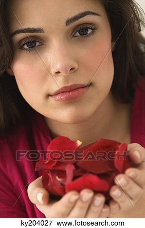 Portrait of a woman holding a handful of red rose petals View Large Photo Image Stock Photo - Portrait of a woman holding a handful of red rose petals. Fotosearch