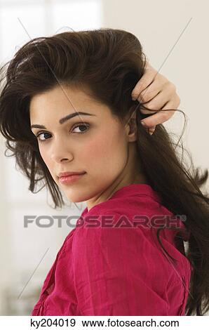Portrait of a woman with her hand in her hair View Large Photo Image Stock Photo - Portrait of a woman with her hand in her hair. Fotosearch