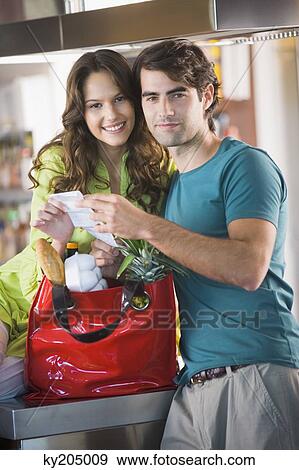 Stock Photo - Couple holding a shopping bill. Fotosearch