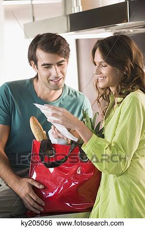 Couple reading a shopping bill View Large Photo Image Stock Photograph - Couple reading a shopping bill. Fotosearch
