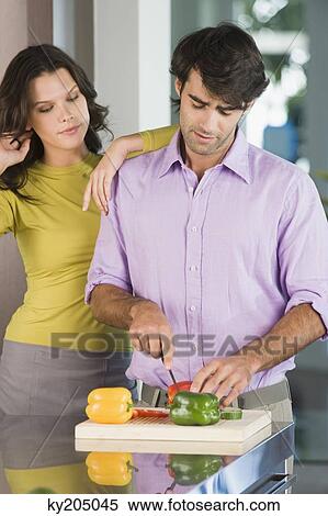 Man cutting bell peppers with a woman standing beside him View Large Photo Image Stock Photography - Man cutting bell peppers with a woman standing beside him. Fotosearch