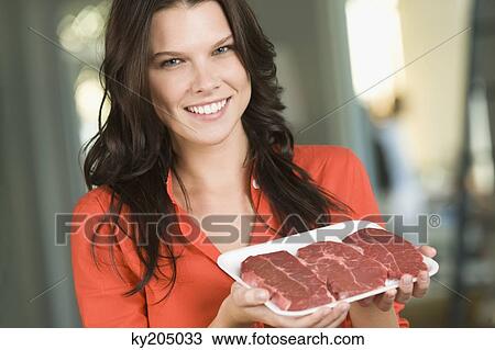 Woman holding a tray of meat View Large Photo Image Stock Image - Woman holding a tray of meat. Fotosearch