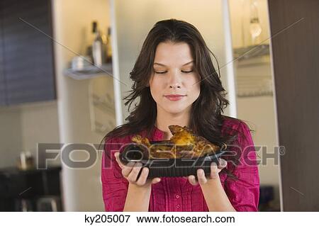 Woman holding a tray of roasted chicken View Large Photo Image Stock Photo - Woman holding a tray of roasted chicken. Fotosearch