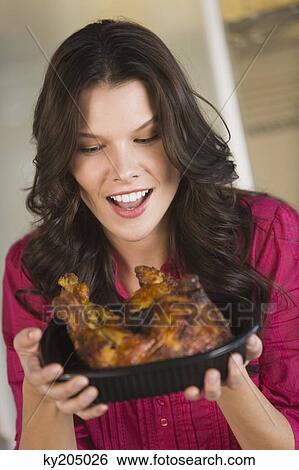 Woman holding a tray of roasted chicken View Large Photo Image Stock Photograph - Woman holding a tray of roasted chicken. Fotosearch